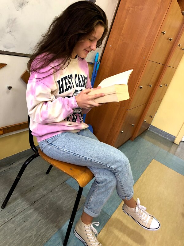 dziewczyna czytająca książkę, siedząca na krześle